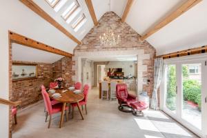 a dining room with a wooden table and red chairs at Riverside Cottage - Wareham in Wareham