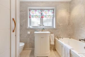 a bathroom with a sink and a tub and a window at Riverside Cottage - Wareham in Wareham +41 photos