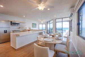a kitchen and living room with a table and chairs at Luna Azul 8: Beachfront Paradise in Akumal in Akumal