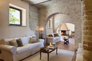 ein Wohnzimmer mit einem weißen Sofa und einer Ziegelwand in der Unterkunft Assisi villa rental in Santa Maria degli Angeli