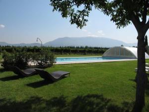 ein Hof mit zwei Stühlen im Gras neben einem Pool in der Unterkunft Assisi villa rental in Santa Maria degli Angeli