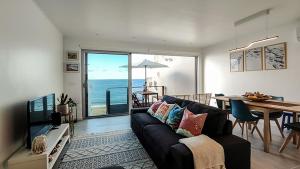 Una sala de estar con un sofá y una mesa de comedor. en Água Salgada, en Ponta Delgada
