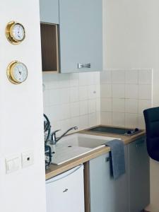 une petite cuisine avec un évier et un comptoir dans l'établissement Apartment - Equemauville - Normandie, à Équemauville