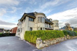 a large white house with a hedge in front of it at Flat 9 Broadleys in Swanage