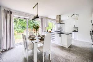 une cuisine avec des armoires blanches et une table et des chaises dans l'établissement Fawn House, à Olton