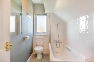 a bathroom with a toilet and a tub and a sink at Sunshine Cottage - West Bexington in Swyre +13 photos