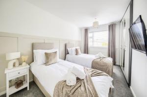 Cette chambre blanche dispose de 2 lits et d'une télévision. dans l'établissement Fawn House, à Olton