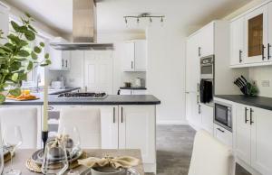 une cuisine avec des armoires blanches et des comptoirs noirs dans l'établissement Fawn House, à Olton