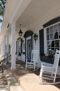 a porch with two white rocking chairs on a house at Parry Lodge in Kanab