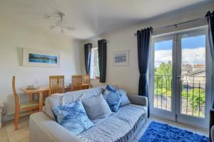 a living room with a couch and a sliding glass door at 3 The Downs in Swanage