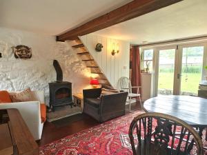 ein Wohnzimmer mit einem Kamin und einer Steinmauer in der Unterkunft Far End Cottage in Fyfield