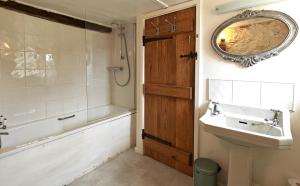 ein Badezimmer mit Waschbecken, Badewanne und Spiegel in der Unterkunft Far End Cottage in Fyfield + 23 Fotos