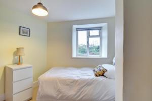 a bedroom with a bed and a window at Meadow Cottage in Bridport +5 photos