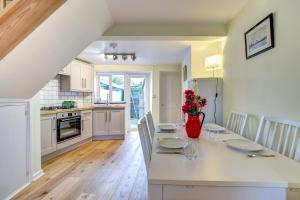 a kitchen with a table with a vase of flowers on it at Meadow Cottage in Bridport