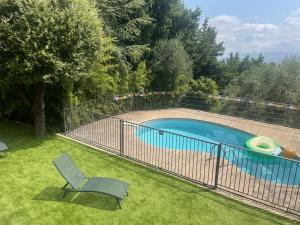 ein Zaun um einen Swimmingpool mit einem Stuhl in der Unterkunft Sensivilla Guest House - Grasse - Costa Azzurra in Grasse