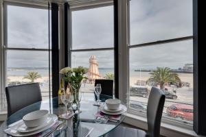 comedor con mesa de cristal y vistas a la playa en 4 At The Beach, en Weymouth
