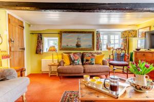 a living room with a couch and a table at Olive Tree Cottage in Portesham