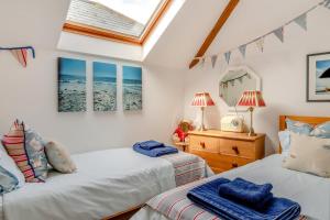 a bedroom with two beds and a skylight at Olive Tree Cottage in Portesham