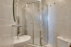 a bathroom with a shower and a sink and a toilet at Flat 6 Penlu in Swanage