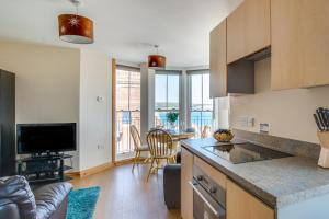a kitchen and living room with a table and chairs at Flat 6 Penlu in Swanage +6 photos