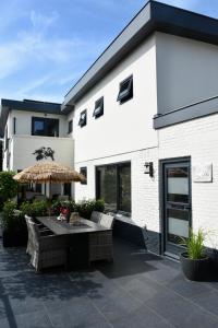 a patio with a table and an umbrella at Costa C en E in Noordwijk