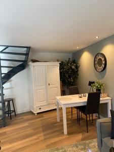 a living room with a table and a white cabinet at Costa C en E in Noordwijk