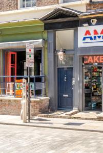 a store front with a blue door on a street at Spacious 2Bed Central Liverpool Nightlife & Events, sleeps up to 10 in Liverpool