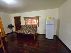 a living room with a couch and a refrigerator at The Tranquil Ranch House at Freshwater Creek Cabanas in Commerce Bight Village