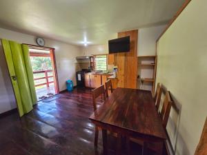 a dining room with a wooden table and a kitchen at The Tranquil Ranch House at Freshwater Creek Cabanas in Commerce Bight Village
