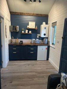 a kitchen with blue cabinets and a white refrigerator at Little Rock Cabin in Ballynagore
