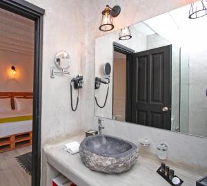 a bathroom with a large stone sink and a mirror at Camara Studio Mykonos in Ornos +64 photos