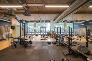 a gym with a lot of treadmills and machines at Modern Apartment in Wembley Park with Cinema, Gym & Games room in London