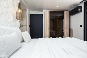 a large white bed with white pillows on it at Ares Suites 3 in Plataria