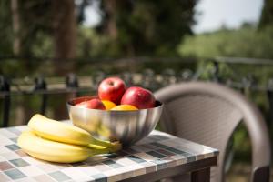a bowl of fruit on a table with bananas and apples at Casa Angelina 2 in Laganas +20 photos