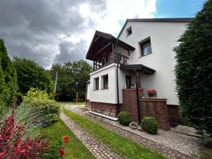 a white house with a balcony on top of it at Słupiecki Zakątek in Nowa Ruda