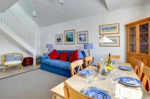 a dining room with a table and a blue couch at 6a Springfield Road in Swanage