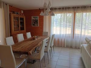 a dining room with a wooden table and white chairs at Chalet Risoul jusqu'à 8 personnes in Risoul