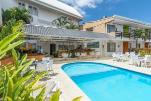 a villa with a swimming pool and patio furniture at Hotel Residence Inn Suites Cristina in San José