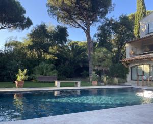 a swimming pool in front of a house at La Beluga in Sainte-Maxime