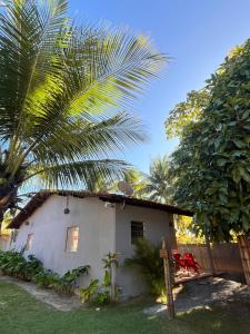 サン・ミゲル・ドス・ミラーグレスにあるVilla Abaréのヤシの木が隣にある小さな白い家