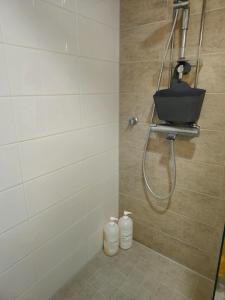 a bathroom with a shower with a basket on the wall at 3room apartment at central Jyväskylä in Jyväskylä
