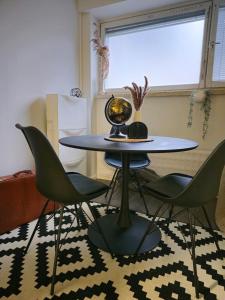a table with chairs and a globe on a rug at 3room apartment at central Jyväskylä in Jyväskylä