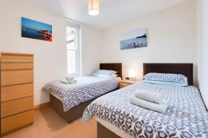 a bedroom with two beds and a window at Flat 7 Penlu in Swanage