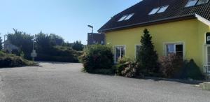 a yellow house with a parking lot next to it at Motorest u Štěpána in Litohoř