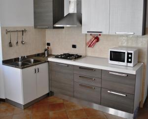 cocina con fregadero y microondas en la encimera en Villa Ortensia, en Oliveto Lario