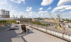 Una terraza con dos sillas y vista a un puerto. en ApartamentyGdansk eu - ŻURAWIE II - I, en Gdansk