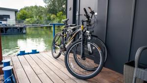 two bikes are parked on a dock next to the water at Captains Danube Houseboat - Bratislava in Jarovce