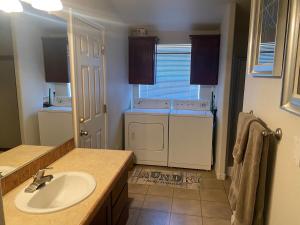 een badkamer met een wastafel, een wasmachine en een droger bij Parker Pair - Sunset Escape in Parker +12 foto's