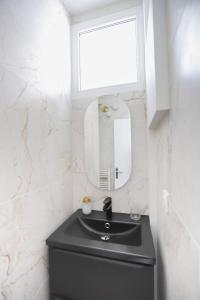 a bathroom with a black sink and a mirror at Studio calme avec extérieur et entrée autonome in Saint-Sébastien-sur-Loire