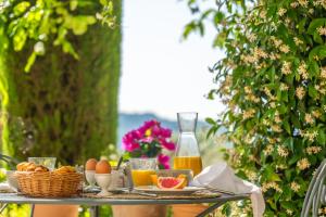 a table with food and oranges and a bottle of orange juice at Mas Bella Cortis in La Garde-Adhémar